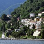 Casas coloridas em colina arborizada à beira do Lago de Como